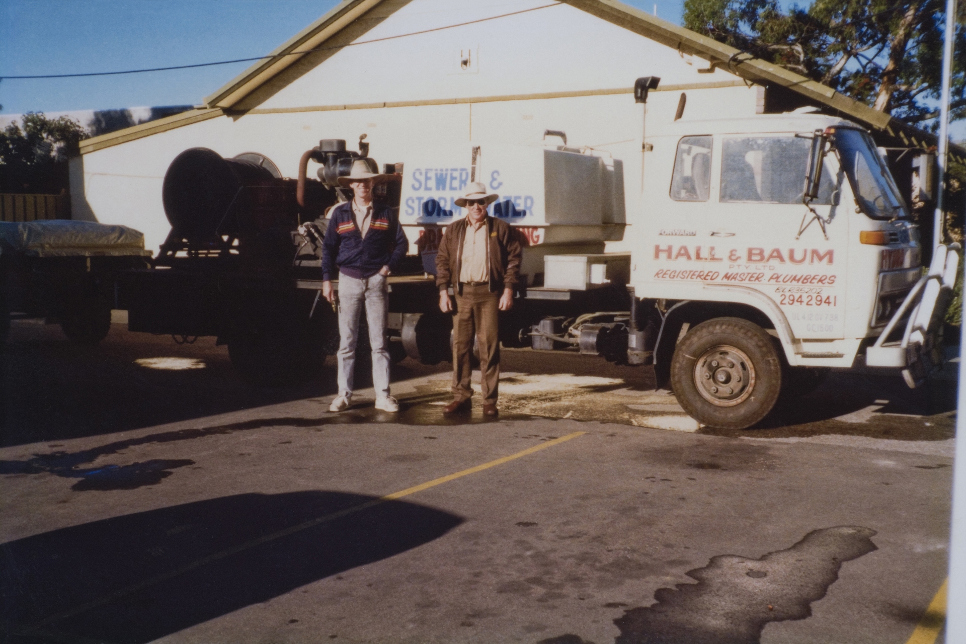 Two generations of the Hall & Baum family with an early Registered Master Plumbers truck